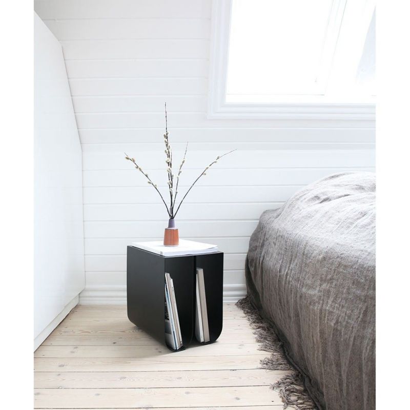 black curved  side table in a bedroom by Kristina Dam